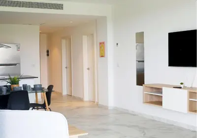 a living room with a table and a tv on a wall at Spacious 3BR Residence in Punta Cana by Infinity Homes in Punta Cana