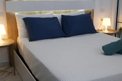 a bedroom with a bed with blue pillows and two lamps at Spacious 3BR Residence in Punta Cana by Infinity Homes in Punta Cana