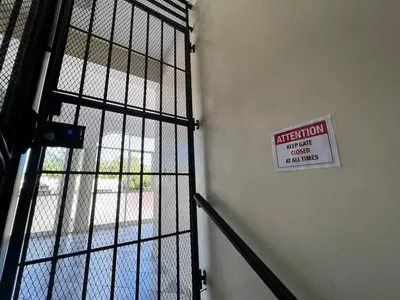 a metal door with a sign on it next to a building at Plaza Achim 6B, Modern APT 250m from Sosua beach! in Sosúa