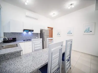 a kitchen with white cabinets and a counter top at Plaza Achim 6B, Modern APT 250m from Sosua beach! in Sosúa