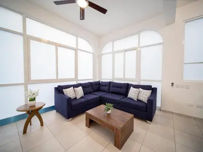 a living room with a blue couch and a table at Plaza Achim 6B, Modern APT 250m from Sosua beach! in Sosúa