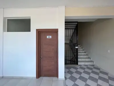 a hallway with a wooden door and stairs at Plaza Achim 6A, Modern APT 250m from Sosua beach! in Sosúa