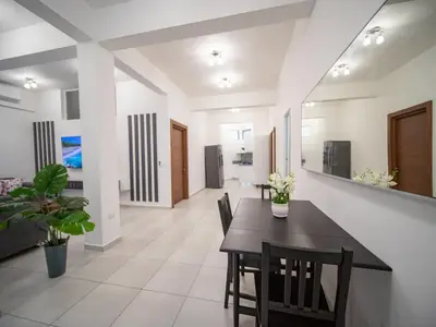 a dining room with a black table and chairs at Plaza Achim 6A, Modern APT 250m from Sosua beach! in Sosúa