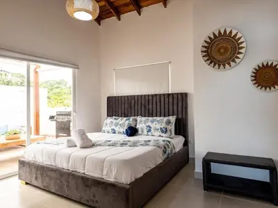 a bedroom with a large bed and a mirror at Rooftop Penthouse Jacuzzi, 2 Pools Playa Popy 500m in Las Terrenas