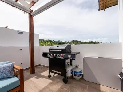a grill sitting on top of a balcony at Rooftop Penthouse Jacuzzi, 2 Pools Playa Popy 500m in Las Terrenas
