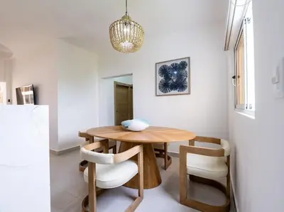 a dining room with a wooden table and chairs at Rooftop Penthouse Jacuzzi, 2 Pools Playa Popy 500m in Las Terrenas
