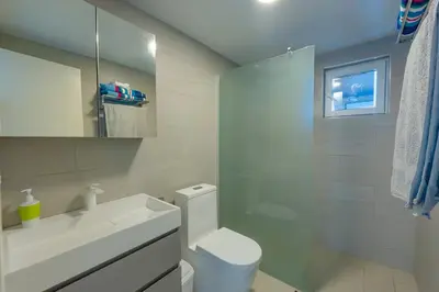 a white bathroom with a toilet and a sink at Prime Apartment with Fast Internet & Washer in SOV in Sosúa