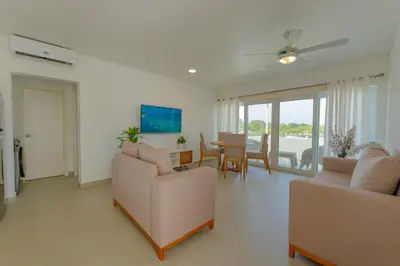 a living room with two couches and a table and chairs at Prime Apartment with Fast Internet & Washer in SOV in Sosúa
