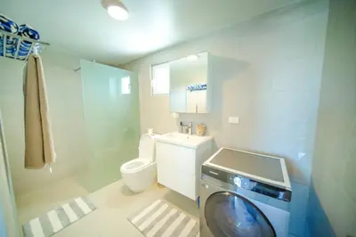 a bathroom with a washing machine and a toilet at Work & Relax Studio Pools & Fast Wi-Fi in SOV in Sosúa