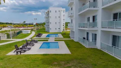 an apartment building with chairs and a swimming pool at Work & Relax Studio Pools & Fast Wi-Fi in SOV in Sosúa