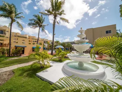 a fountain in the middle of a park with palm trees at Garden Condos APT 3 - Affordable 1BR APT in Sosua in Sosúa