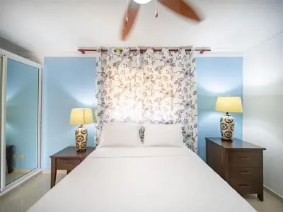 a bedroom with a white bed and two lamps at Garden Condos 9 Affordable APT in Sosua downtown in Sosúa