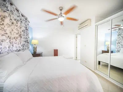 a bedroom with a white bed and a ceiling fan at Garden Condos 9 Affordable APT in Sosua downtown in Sosúa