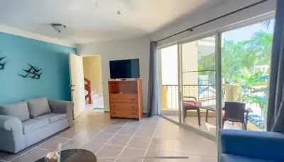 a living room with a couch and a tv at Garden Condos 10 2BR Apt in Sosua Strip in Sosúa