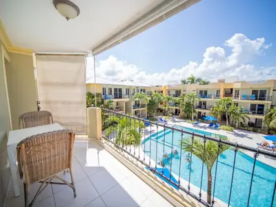 a balcony with a view of a pool and buildings at Garden Condos APT 30 Lovely 1BR Condo with Pool in Sosúa