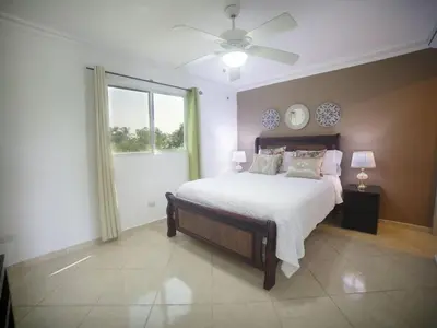 a bedroom with a large bed and a window at Garden Condos 35 Best Stylish apartment in Sosua in Sosúa