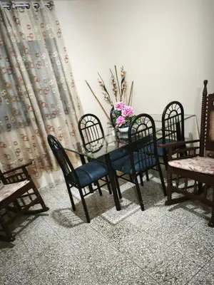 a dining room table with chairs and a vase of flowers on it at Espacio acogedor y funcional in SJM