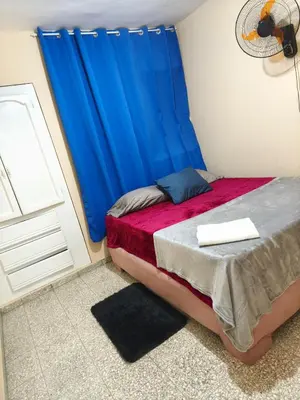 a bedroom with a bed with a blue curtain at Espacio acogedor y funcional in SJM