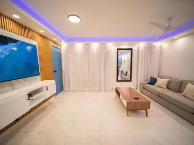 a living room with a large tv and a couch at Garden Condos 39 Ultra modern apartment in Sosua in Sosúa