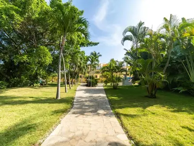 a path through a park with palm trees at Garden Condos 39 Ultra modern apartment in Sosua in Sosúa
