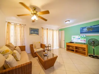 a living room with a couch and a flat screen tv at Charming 1BR Apt with Pool Walk to Sosua Beach in Sosúa