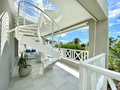a spiral staircase on a house with a balcony at Luxury Penthouse with roof top & infinitive pool ocean view in Tracadero Beach Club in Bayahibe