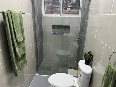 a bathroom with a shower with a toilet and a sink at Maravilla Bayahibe , Stylish Apartment, Pool a Wifi in Bayahibe