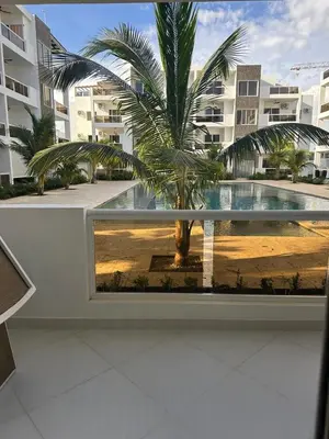 a palm tree is seen through a window in a building at Maravilla Bayahibe , Stylish Apartment, Pool a Wifi in Bayahibe