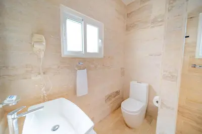 a bathroom with a toilet and a sink and a window at Luxury 2BR Villa next to Santa Fe in Sosúa