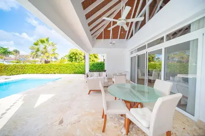 a dining room with a table and chairs and a pool at Luxury 2BR Villa next to Santa Fe in Sosúa