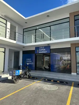 a motorcycle parked in a parking lot in front of a building at Appartement lumineux, piscine & plage proche in Punta Cana