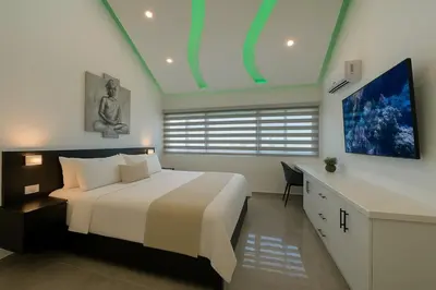 a bedroom with a large white bed and a desk at Stylish Sosua 2 BR apartment near everything in Sosúa