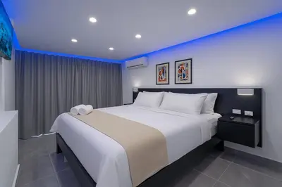 a bedroom with a large white bed with blue lighting at Stylish Sosua 2 BR apartment near everything in Sosúa