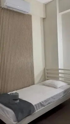 a bedroom with a white bed with a blanket on it at Yuloren Hostal 1 min del monumento & 5 de Agora Mall in Santiago de los Caballeros
