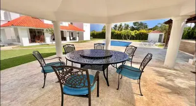 a black table and chairs under an umbrella at 10 bedroom huge villa close to Sosua downtown in Sosúa