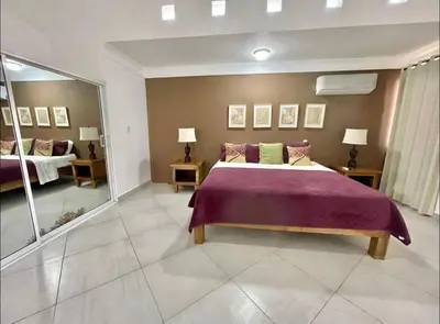 a bedroom with a large bed and a mirror at 10 bedroom huge villa close to Sosua downtown in Sosúa