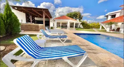two lounge chairs and a table next to a swimming pool at 10 bedroom huge villa close to Sosua downtown in Sosúa