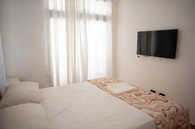 a bedroom with a bed and a flat screen tv at Presmita rose 24 in Punta Cana