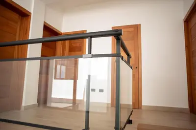 a glass railing in a room with a window at Presmita rose 24 in Punta Cana