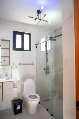 a bathroom with a toilet and a glass shower at Presmita rose 24 in Punta Cana