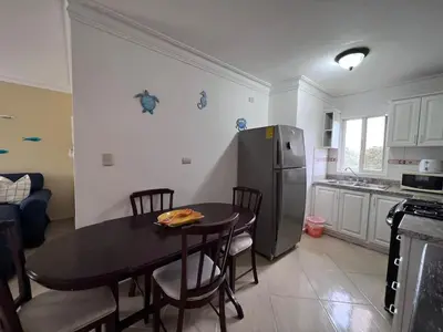 a kitchen with a table and a stainless steel refrigerator at Garden Condos 48 - Friendly 1BR APT Sosua Center in Sosúa