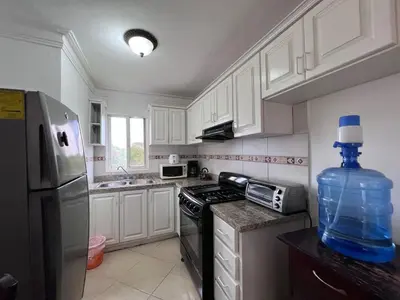 a kitchen with white cabinets and a water bottle on the counter at Garden Condos 48 - Friendly 1BR APT Sosua Center in Sosúa