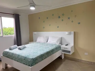 a bedroom with a bed with blue stars on the wall at Garden Condos 48 - Friendly 1BR APT Sosua Center in Sosúa
