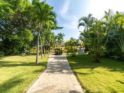 a path through a park with palm trees at Garden Condos 48 - Friendly 1BR APT Sosua Center in Sosúa