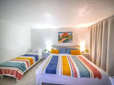 two beds sitting in a room with curtains at Central 1BR APT - 1 minute Walking from Rumba in Sosúa