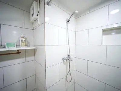 a white bathroom with a shower with a shower head at Central 1BR APT - 1 minute Walking from Rumba in Sosúa