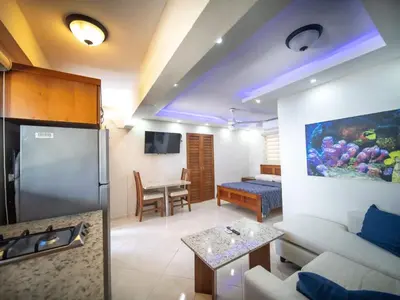 a kitchen and living room with a couch and a table at Casa de Compai Studio 1 AC WiFi Prime Location in Sosúa