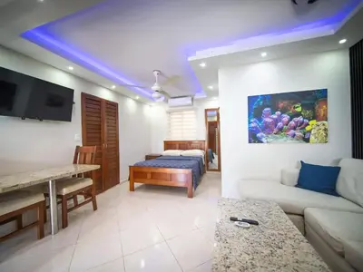 a living room with a couch and a bed in a room at Casa de Compai Studio 1 AC WiFi Prime Location in Sosúa