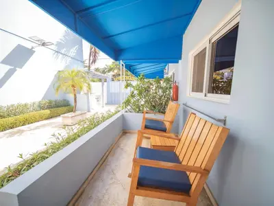 two chairs on a balcony with a blue roof at Casa de Compai Studio 2 Walk to Beach & Fun in Sosúa
