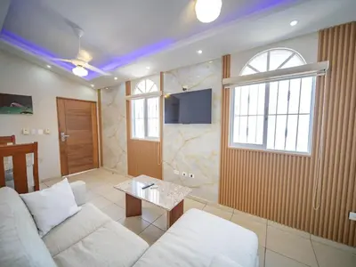 a living room with a white couch and a tv at CC 3 Casa de Compai Unit 3 Steps to Everything in Sosúa